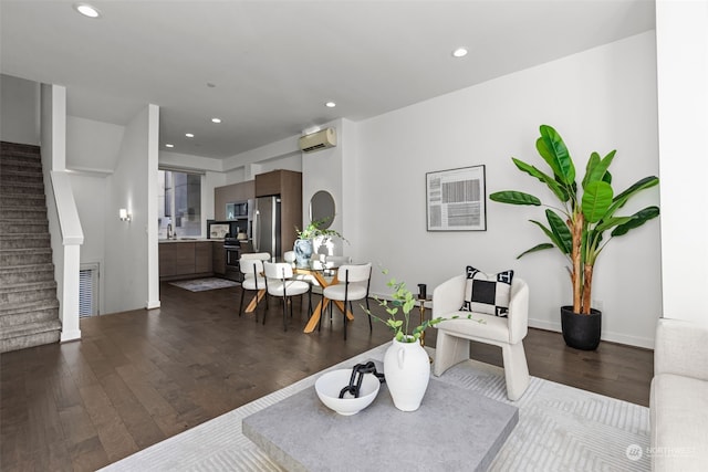 living room with sink, an AC wall unit, and dark hardwood / wood-style flooring