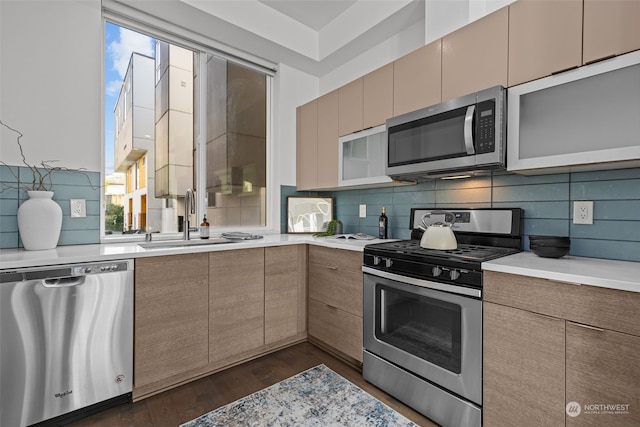 kitchen with sink, backsplash, dark wood-type flooring, and stainless steel appliances