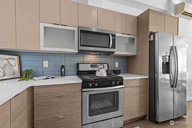 kitchen featuring light wood-type flooring, a wall mounted air conditioner, appliances with stainless steel finishes, and tasteful backsplash