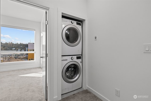 laundry room featuring carpet, stacked washer / drying machine, and a healthy amount of sunlight