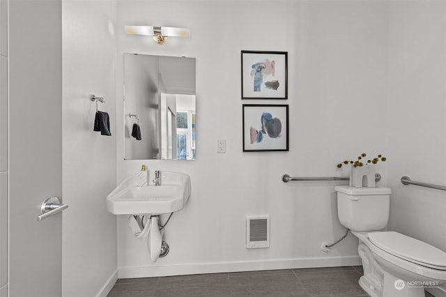 bathroom featuring toilet and tile patterned flooring