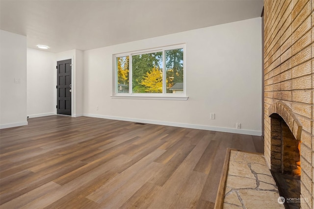 unfurnished living room featuring a fireplace and wood-type flooring