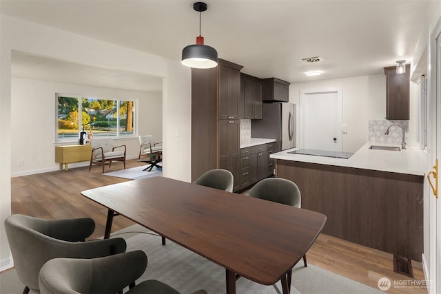 dining room with sink and light wood-type flooring