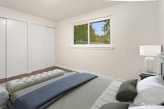 bedroom with multiple closets and hardwood / wood-style floors