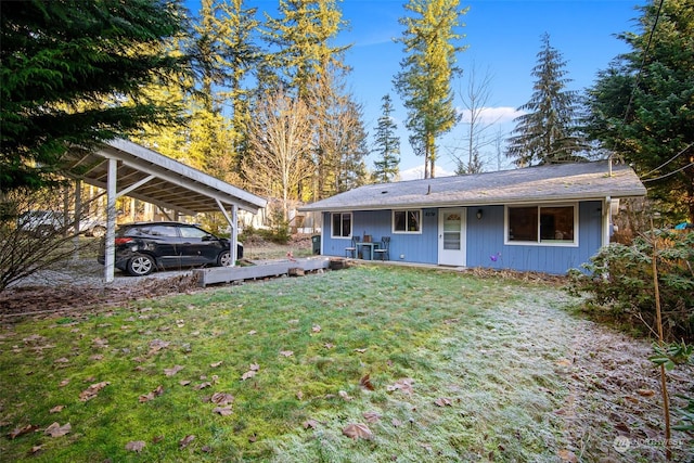 back of property featuring a lawn and a carport