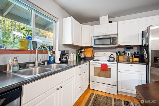 kitchen featuring stainless steel appliances, light hardwood / wood-style floors, white cabinetry, and sink