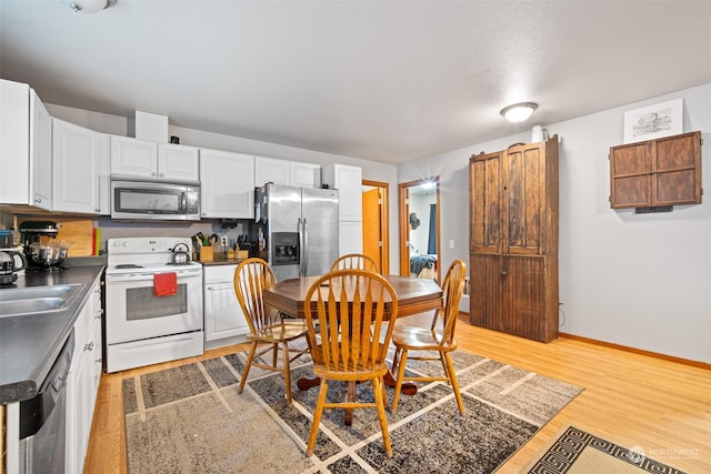 kitchen with sink, white cabinetry, stainless steel appliances, and light wood-type flooring