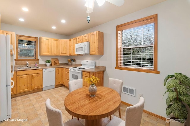 kitchen with light brown cabinets, light tile patterned floors, sink, and white appliances