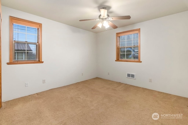 carpeted spare room featuring ceiling fan