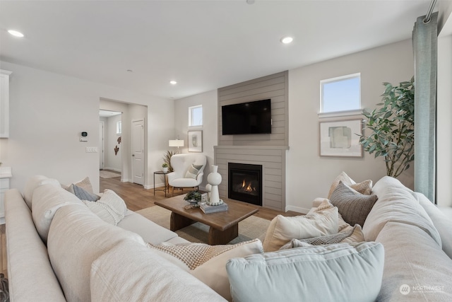 living room featuring light wood-type flooring and a large fireplace