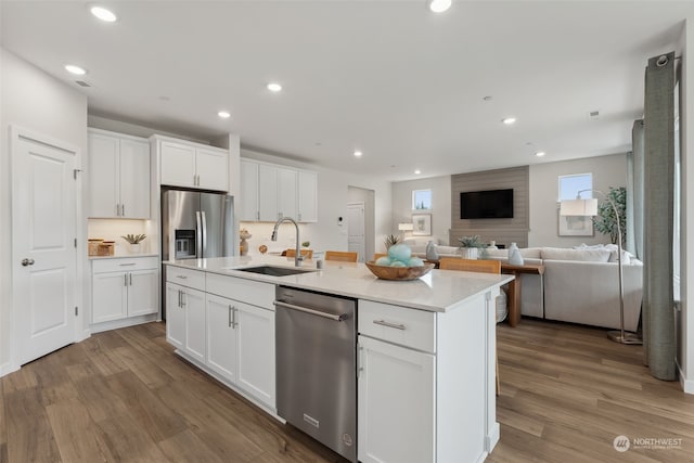 kitchen featuring sink, white cabinetry, and a center island with sink