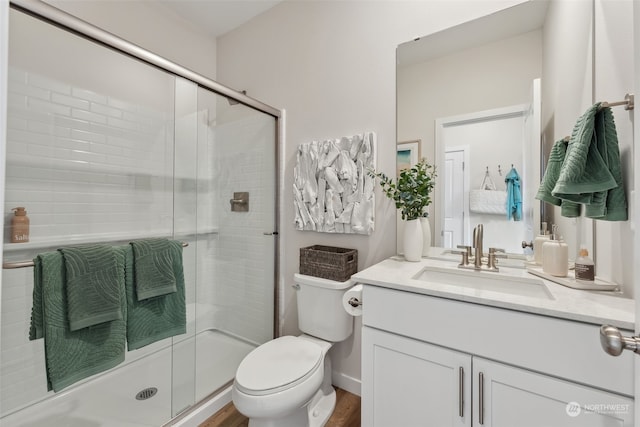 bathroom featuring walk in shower, vanity, toilet, and hardwood / wood-style floors