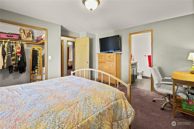 bedroom with ensuite bath, light colored carpet, and a closet