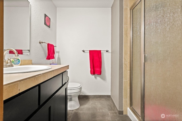 bathroom with a shower with door, vanity, and toilet