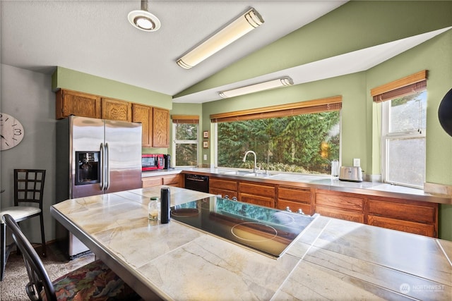 kitchen featuring lofted ceiling, sink, tile counters, and black appliances