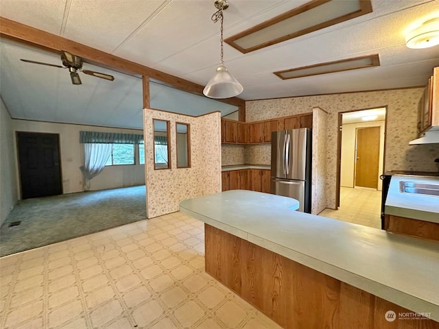 kitchen with light carpet, stainless steel fridge, ceiling fan, hanging light fixtures, and vaulted ceiling