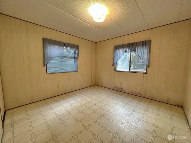 spare room featuring wooden walls