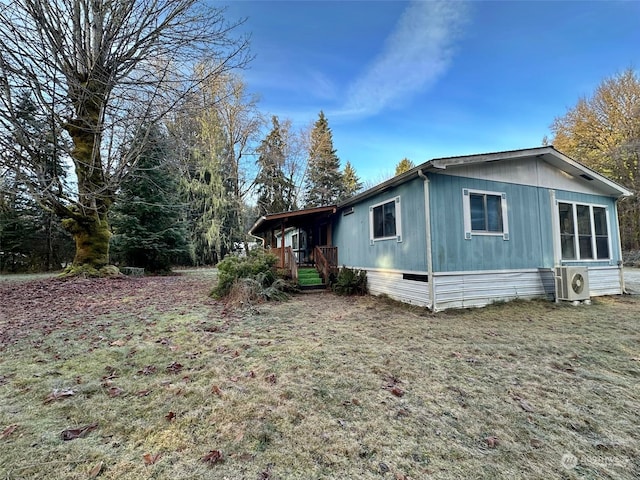 view of side of property featuring a yard and ac unit