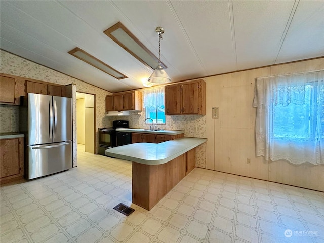 kitchen featuring pendant lighting, sink, kitchen peninsula, stainless steel refrigerator, and electric range