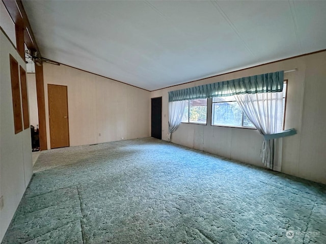 carpeted spare room featuring vaulted ceiling