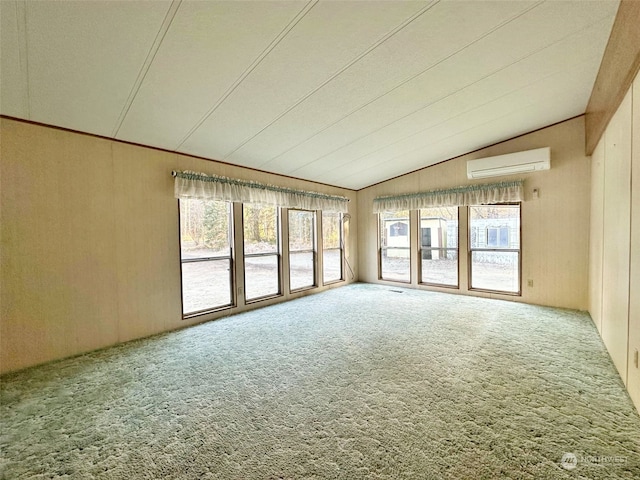 spare room featuring carpet, plenty of natural light, and a wall mounted air conditioner