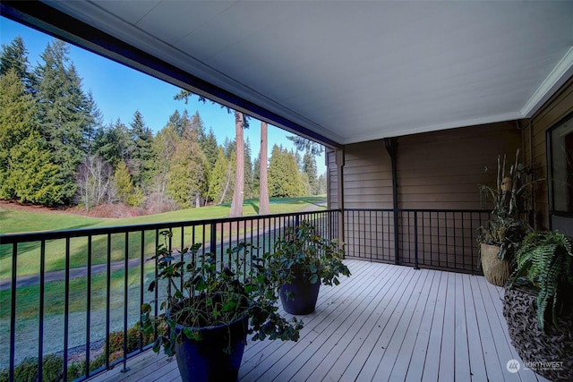 wooden deck featuring a lawn