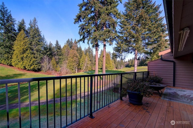 wooden terrace with an outdoor fire pit and a yard