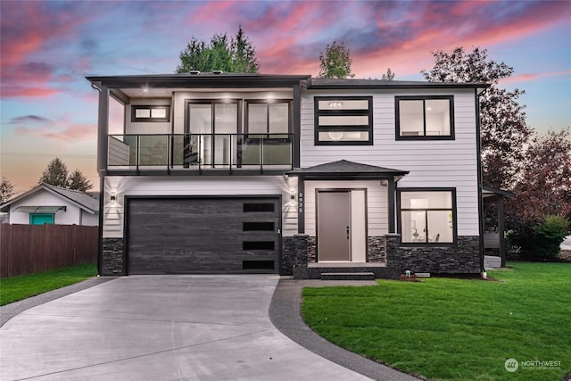 view of front of home with a balcony, a garage, and a yard