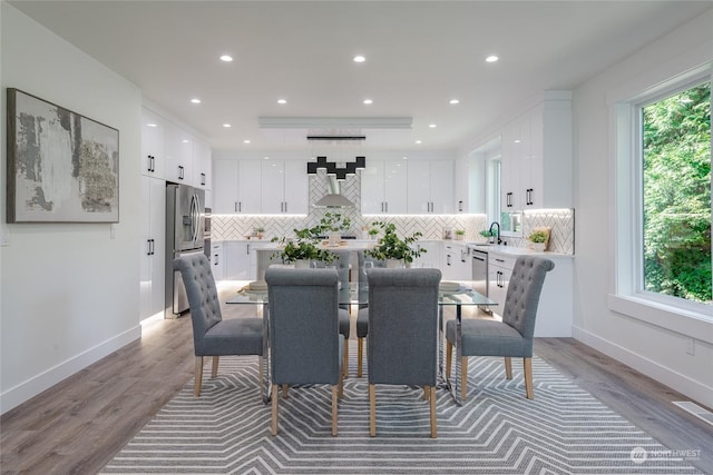 dining room featuring hardwood / wood-style floors, sink, and a healthy amount of sunlight