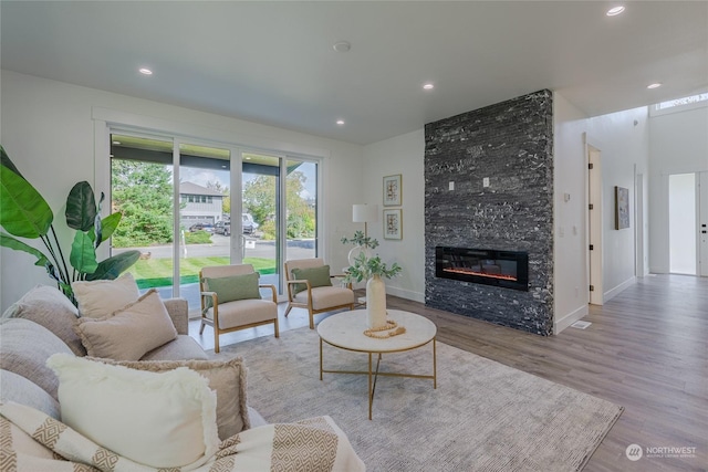 living room with light wood-type flooring and a fireplace