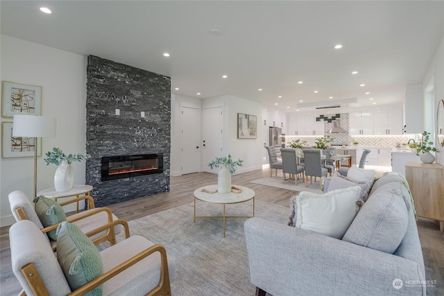 living room with a large fireplace and light hardwood / wood-style floors