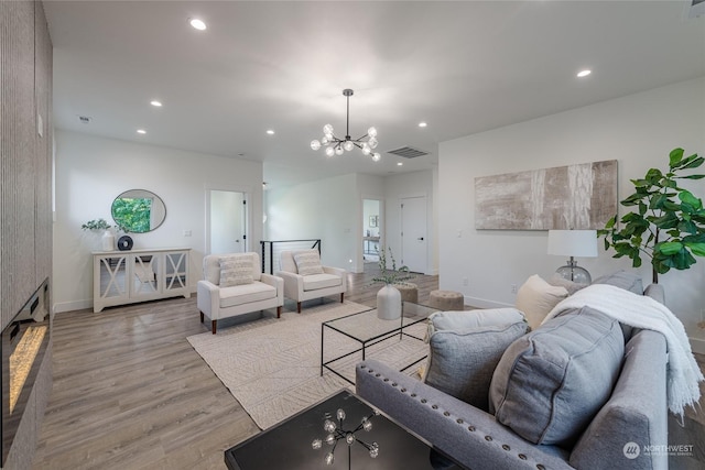 living room featuring a chandelier and light hardwood / wood-style floors