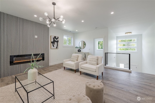 living room featuring a notable chandelier and light wood-type flooring