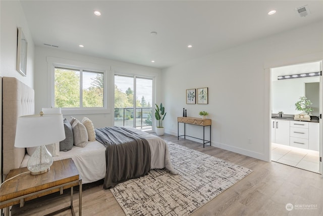 bedroom with access to exterior and light hardwood / wood-style flooring