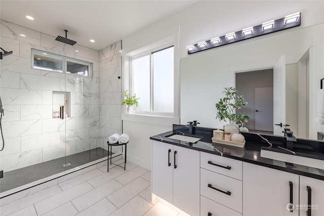 bathroom with tiled shower and vanity