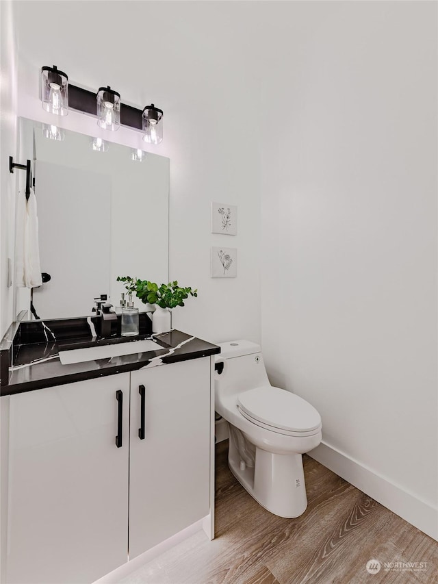 bathroom with vanity, toilet, and hardwood / wood-style floors