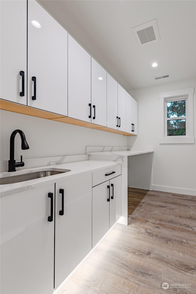 interior space featuring sink and light hardwood / wood-style flooring