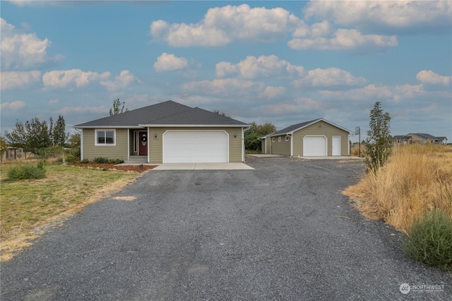 ranch-style house with a garage and an outbuilding