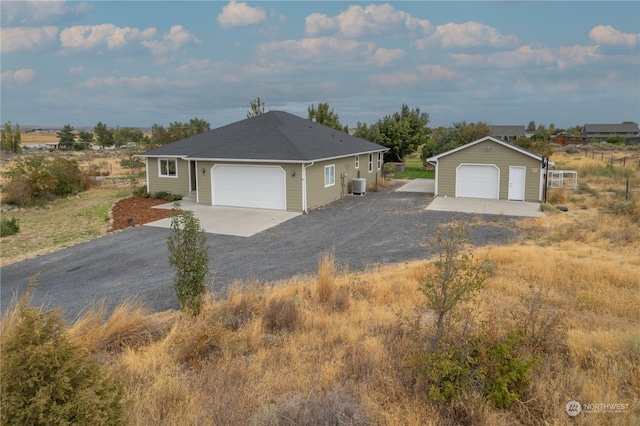 view of front of home with central air condition unit and a garage