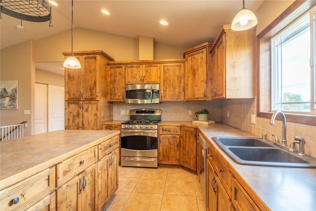 kitchen featuring decorative light fixtures, tasteful backsplash, lofted ceiling, sink, and stainless steel appliances