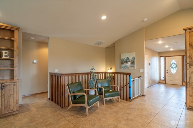 living area with light tile patterned floors and vaulted ceiling