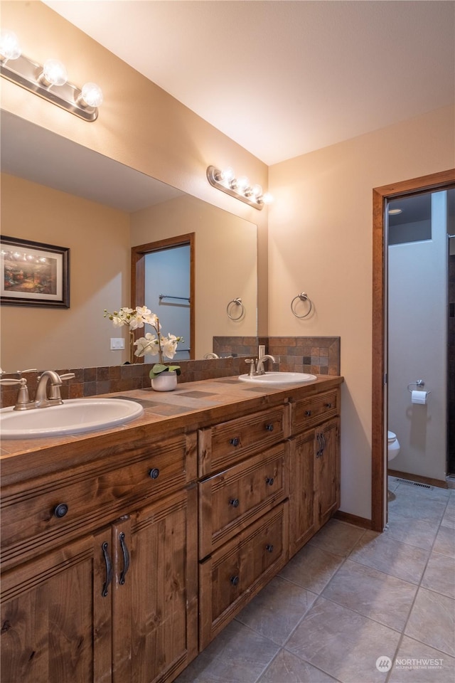 bathroom with toilet, tile patterned floors, and vanity