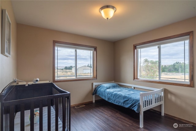 bedroom with dark hardwood / wood-style flooring