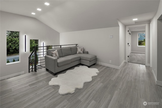 living room featuring vaulted ceiling and light wood-type flooring