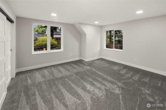 bonus room featuring dark carpet