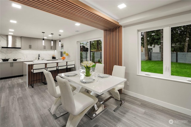 dining space with sink and light hardwood / wood-style floors