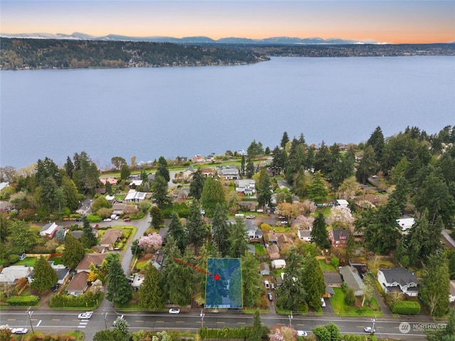 aerial view at dusk featuring a water view