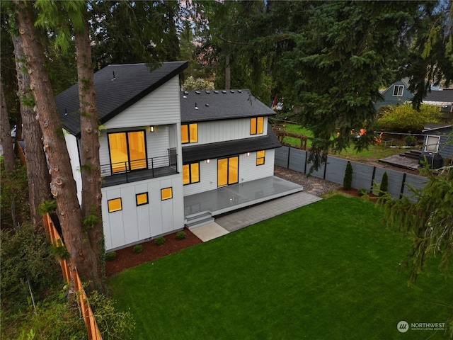 back of house with a yard and a balcony