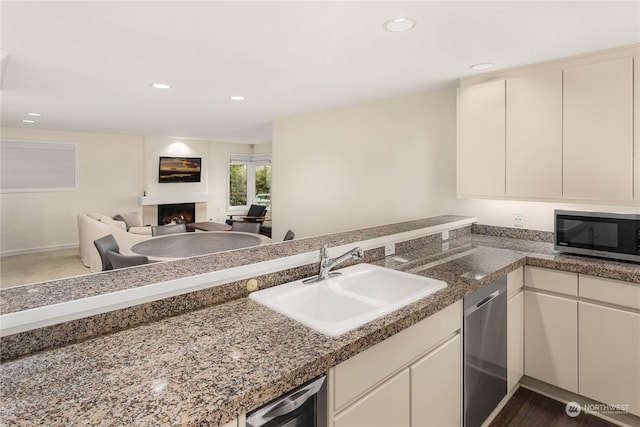 kitchen featuring sink, cream cabinets, stainless steel appliances, and kitchen peninsula