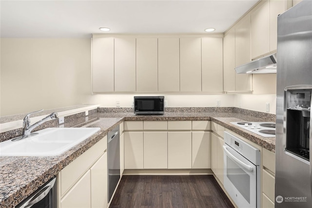 kitchen with appliances with stainless steel finishes, dark hardwood / wood-style floors, sink, and cream cabinetry